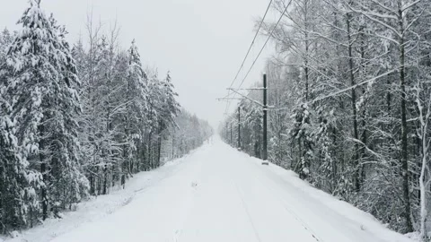 Aerial view drone flies over snow covered railway track in winter forest Video stock 147406630