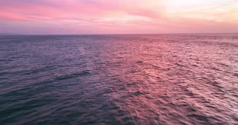 Aerial view of drone flight over the ocean during sunset, water surface in the Stock Footage 254083385