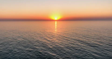 Aerial view of drone flight over the ocean during sunset, water surface in the Stock Footage 254784145