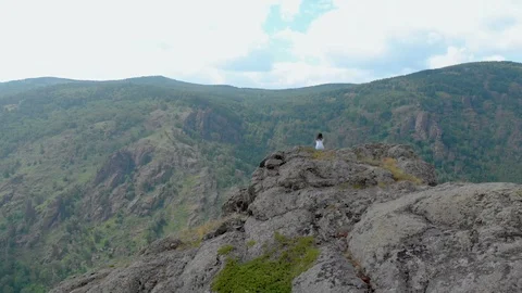 Aerial View, Drone Fly over the seated girl on a cliff face 動画素材 92057531