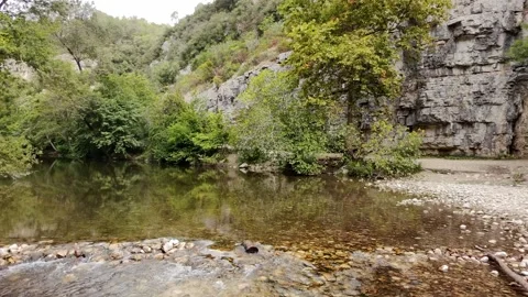 Aerial view from a drone flying low over a peaceful country stream Stock Footage 327965104