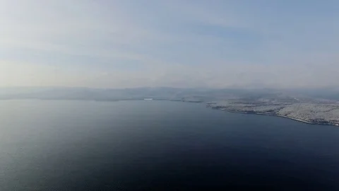 Aerial view of drone flying over lake and a forest at winter time Stock Footage 70693357
