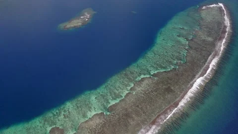 Aerial view of a drone flying over a calm ocean with a coral reef Stock Footage 163119357