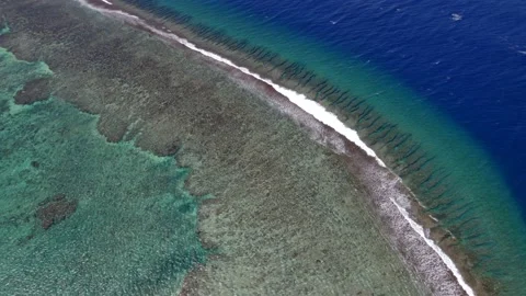 Aerial view of a drone flying over a calm ocean with a coral reef Stock Footage 163119688