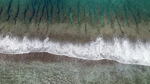 Aerial view of a drone flying over a calm ocean with a coral reef Stock Footage 163119940