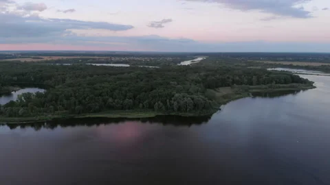 Aerial view from a drone flying over a river during a warm summer sunset. Stock Footage 169501686