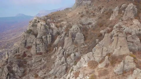 Aerial view of a drone flying over sharp rocky outcrops at sunset. Sharp steep Stock Footage 169999159