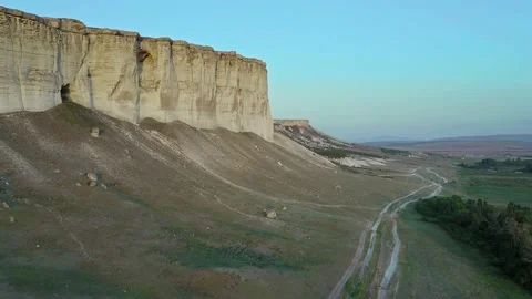 Aerial view of drone flying at sunset along the road and scenic white rock Stock Footage 151454844