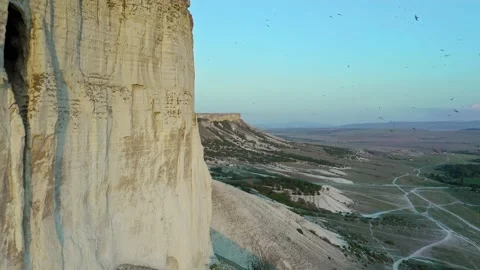 Aerial view of a drone flying at sunset along a picturesque white rock through Stock Footage 151456600