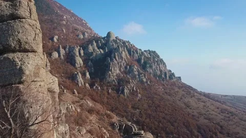 Aerial view of a drone flying through sharp rocky outcrops at sunset. Sharp Stock Footage 172094359