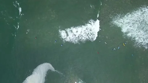 Aerial view with drone looking down of several surfers in the sea Vidéo 143385432
