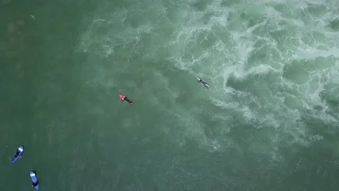 Aerial view with drone looking down of several surfers in the sea Stock Footage 143385619