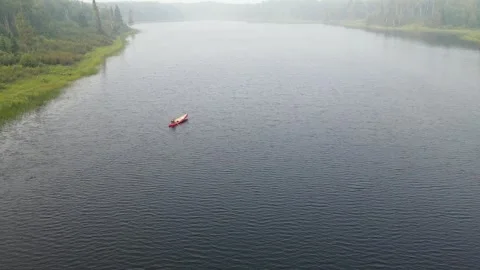 Aerial view from a drone looking down at a person in a red canoe Stock Footage 276280827