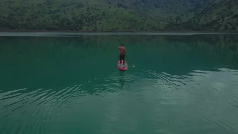 Aerial view by drone of a man practicing Stand Up Paddle or SUP on lake. Stock Footage 239941885