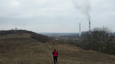 Aerial view from drone of man, running and coughing near Plant pipes pollute atm Stock Footage 152241738