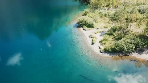 Aerial view; drone moving over mountain lake with torquoise water Stock Footage 120846747