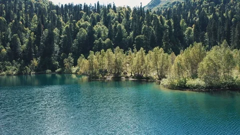 Aerial view; drone moving over mountain lake with torquoise water Stock Footage 120847207