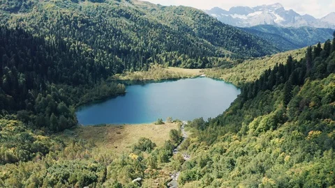 Aerial view; drone moving over mountain lake with torquoise water Stock Footage 120856559