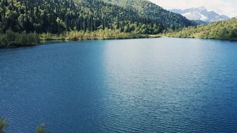 Aerial view; drone moving over mountain lake torquoise water Stock Footage 120886560