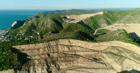 Aerial view with a drone over an open pit mines and carry under the sunlight in Stock Footage 146227363