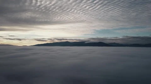 Aerial view from drone panning over clouds and mist Stock Footage 323619308
