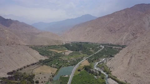 Aerial view with drone of a road between green farm fields and rivers and mounta Stock Footage 144341392