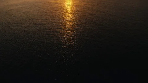 Aerial view of drone slide over the sea surface in the light golden sunset Stock Footage 102063100