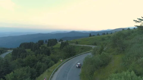 Aerial view drone tracking silver SUV driving through mountain passage road with Stock Footage 157818557
