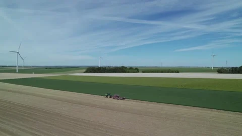 Aerial view by drone of tractor plowing the land wind farm with windmills Stockbeeldmateriaal 166309979