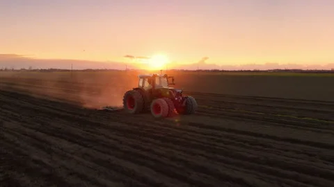Aerial view drone of tractor plowing field at dusk sunset Stock Footage 202163399