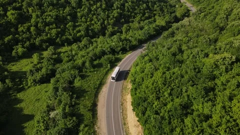 Aerial view drone view on bus on the road trough the trees in mountain rang.. Stock Footage 242355204
