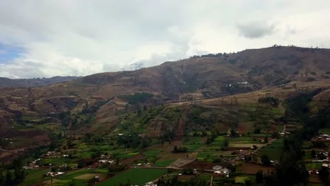 Aerial view from drone while it rains from hills and clouds over pasture lands Stock-Footage 164482332