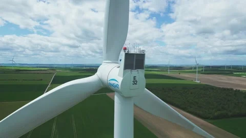 Aerial view by drone of a windmill part of a wind farm showing in the fields Stock Footage