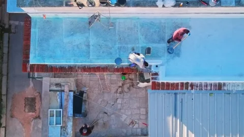 Aerial view with the drone of workers who carry out the waterproofing of a te 스톡 동영상 168802155