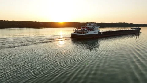 Aerial view. A dry cargo ship sails on the river at sunset.  Stock Footage 234834845