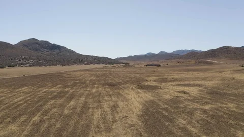 Aerial View of dry empty spanish desert with vegetation and mountains in Stock Footage 119351396