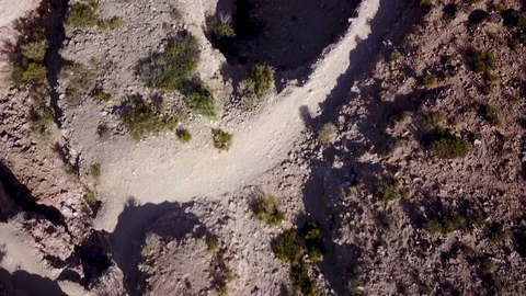 Aerial view of dry riverbed and cactus hill on desert TILT SHOT Stock Footage 88466458