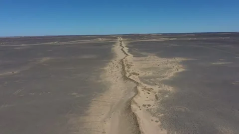 Aerial View of Dry Riverbed Winding Through Arid Desert Landscape Stock Footage 335637075