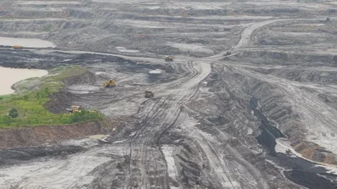 Aerial view of dump truck approaching excavator to load cargo in coal mining Stock Footage 332720249