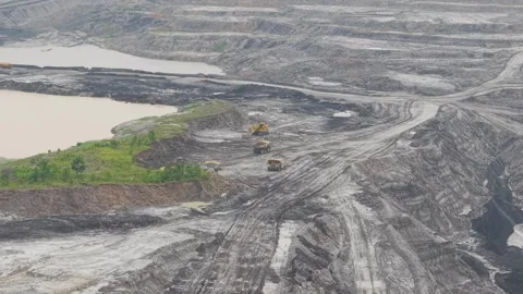 Aerial view of dump truck approaching excavator to load cargo in coal mining Stock Footage 332720295