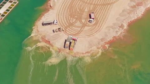 Aerial view of a dump truck unloading sand into water Stock-Footage 345007411