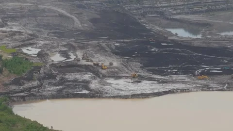 Aerial view of dump trucks queuing in front of an excavator to load coal, c.. Stockbeeldmateriaal 332601222