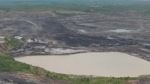 Aerial view of dump trucks queuing in front of an excavator to load coal, c.. Stockbeeldmateriaal 332601533