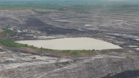 Aerial view of dump trucks queuing in front of an excavator to load coal, c.. Stockbeeldmateriaal 332601599