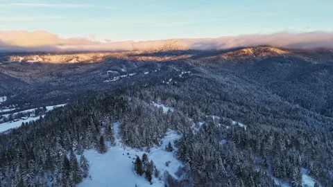 Aerial view during dawn highlights pristine snowfields and serene mountain Stock-Footage 321124450