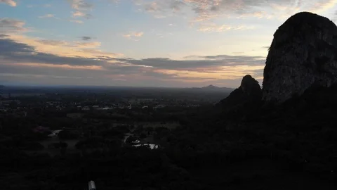 Aerial view during the evening of the bats that are flying out of the cave in Stock Footage 113072745