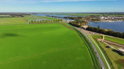 Aerial view of a dutch road between green pastures and a river Stock Footage 320813110