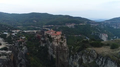Aerial view. Dynamic flight over monastery on top of high cliff in Meteora. Stockbeeldmateriaal 98841580