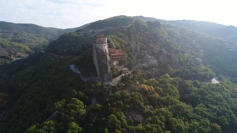 Aerial view. Dynamic flight over monastery on top of high cliff in Meteora. Stockbeeldmateriaal 98843644