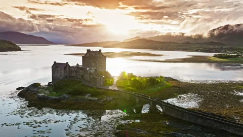 Aerial view of Eilean Donan Castle with long arched bridge and lochside setting. Stock Footage 283495859